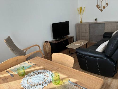 a living room with a table and a couch at Charme'Lin - proche centre ville et gare in Dunkerque