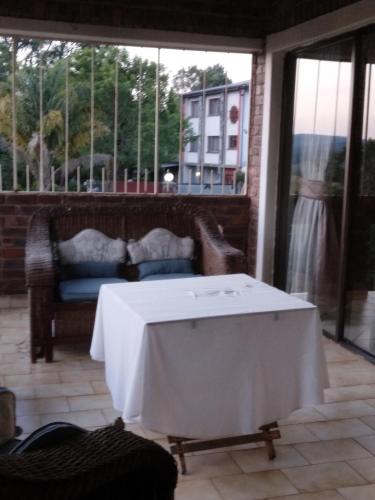 a table with a white table cloth on a patio at Hamba Kancane Ma-Africa Guest House in Graskop