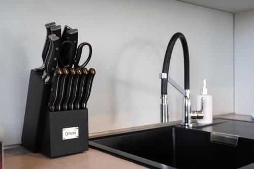 a kitchen counter with a knife block next to a sink at Lux Apts Deluxe Apartment-Zentral-Messe-Küche in Cologne