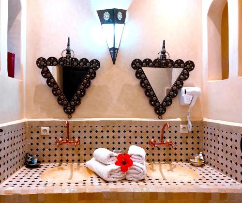 a bathroom with towels and mirrors on the wall at Riad Ain Khadra in Taroudant
