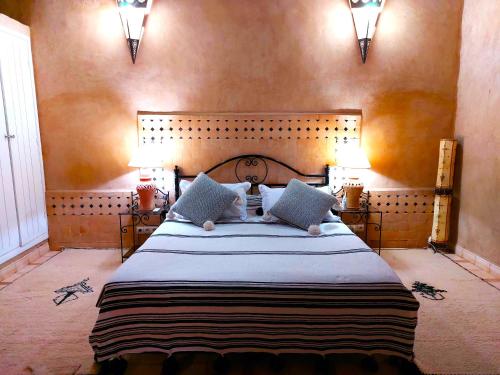 a bedroom with a large bed with two lamps at Riad Ain Khadra in Taroudant