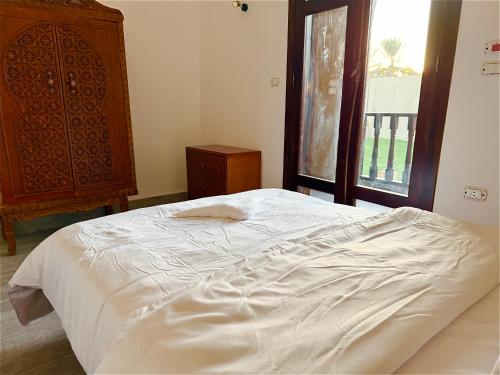 a white bed in a bedroom with a window at Bab Al Shams Palace in Luxor