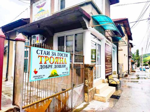 a building with a sign on the side of it at Guest rooms Troyana in Troyan