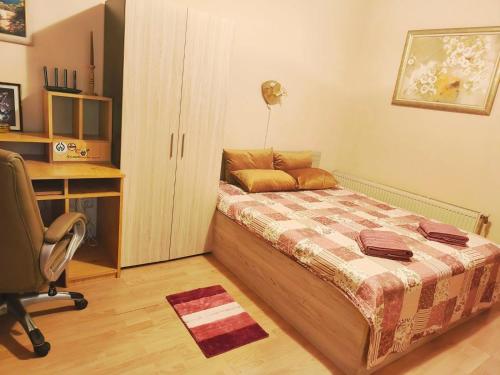 a bedroom with a bed and a desk and a chair at Guest rooms Troyana in Troyan