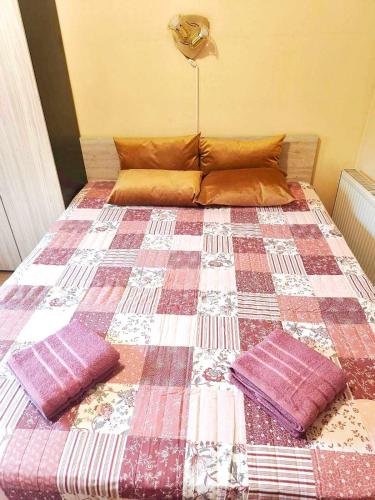 a bed with two pillows on it in a room at Guest rooms Troyana in Troyan