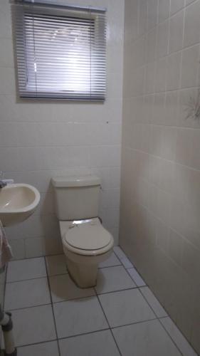 a bathroom with a toilet and a sink at Hamba Kancane Ma-Africa Guest House in Graskop
