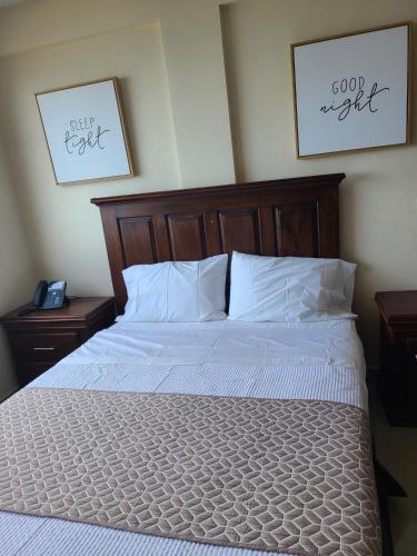 a bed with white sheets and pillows in a bedroom at Comfort Plus Hotel in Cap-Haïtien