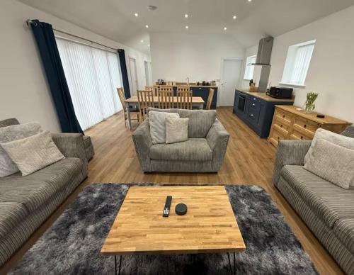 a living room with two couches and a table at Oak View at Moss Bank Farm in Wrexham