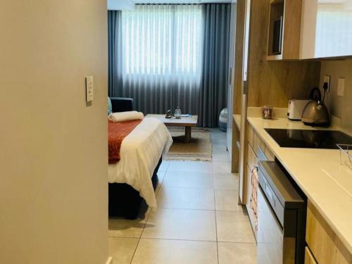 a small room with a bed and a kitchen at Zimbali Lakes Boulevard Suites 145 in Ballito
