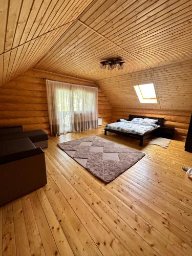 a living room with a bed and a wooden ceiling at Над рікою Міжгірʼя in Mizhhirʼʼya