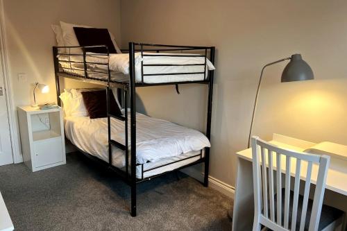 a room with two bunk beds and a desk at Cosy Town House in Bridgnorth in Bridgnorth