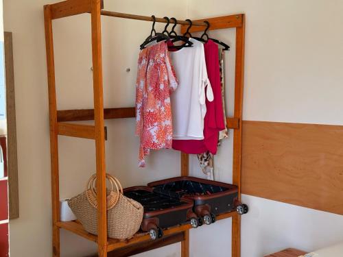 a room with a shelf with a stove and clothes at Suíte Porto das Dunas in Salvador