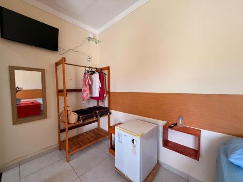 a room with a small refrigerator and a mirror at Suíte Porto das Dunas in Salvador