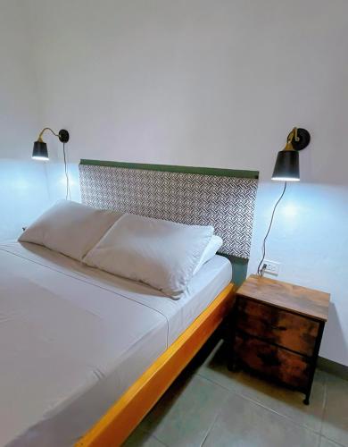 a bedroom with a bed with two lamps and a nightstand at Finca Aisa -Boutique bungalows in Ometepe island in Santa Cruz