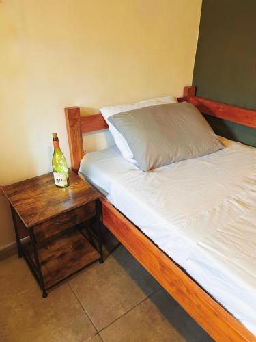 a bed with a wooden frame and a bottle on a table at Finca Aisa -Boutique bungalows in Ometepe island in Santa Cruz