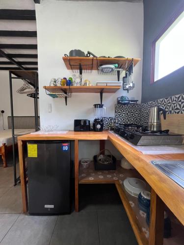 a kitchen with a counter and a black refrigerator at Finca Aisa -Boutique bungalows in Ometepe island in Santa Cruz