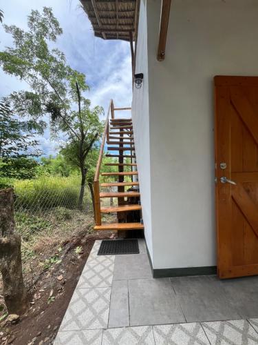 a staircase leading up to a house with a door at Finca Aisa -Boutique bungalows in Ometepe island in Santa Cruz
