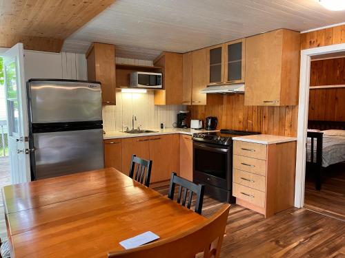 a kitchen with a wooden table and a refrigerator at Camping Chalets Lac St-Augustin in Quebec City
