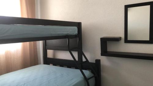 a bunk bed with a mirror on a wall at Marina Diamante - Ilse C in Acapulco