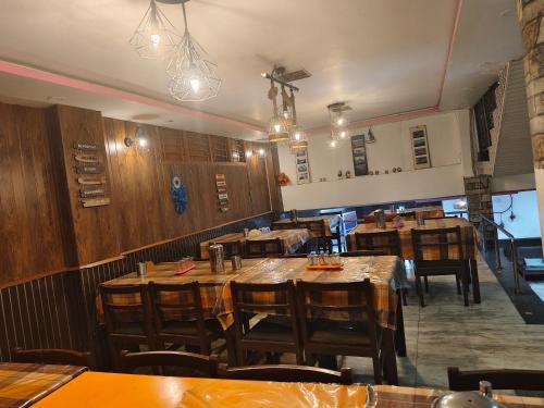an empty restaurant with wooden tables and chairs at Hotel LhoNark Leisure in Gangtok