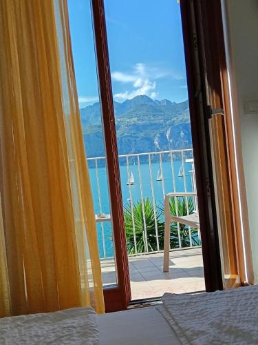 a bedroom with a view of the ocean from a balcony at B&B Casa Sartori in Malcesine