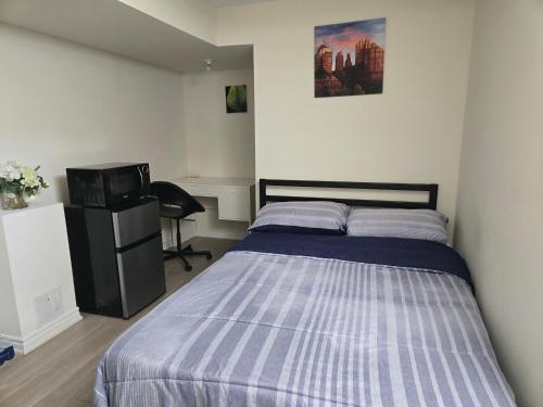Un dormitorio con una cama y un televisor. en One Bed basement Room, en Brampton