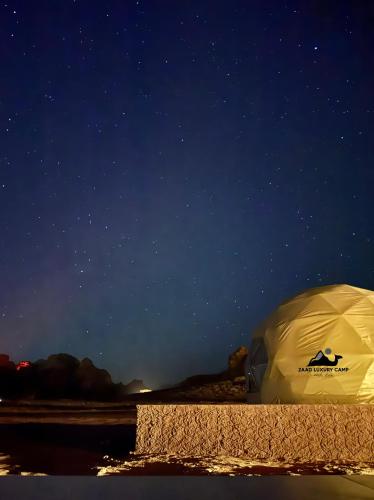 a tent sitting on the beach under a night sky at Wadi Rum ZAAD luxury Camp in Disah