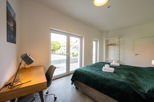 a bedroom with a bed and a desk and a window at Lux Apts Deluxe Apartment-Zentral-Messe-Küche in Cologne