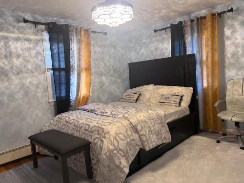 Un dormitorio con una cama, una silla y una lámpara de araña. en 7 Delaney Avenue Dudley MA, en Dudley