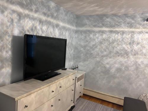 Un televisor de pantalla plana encima de una cómoda. en 7 Delaney Avenue Dudley MA, en Dudley