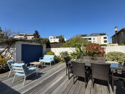 a patio with a table and chairs on a deck at Kaza Blue - Maison familiale Rambouillet centre in Rambouillet