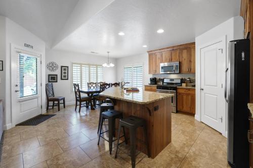 a kitchen with a large island and a dining room at Cozy Home Near Zion With Fire Pit & Patio Dining in La Verkin
