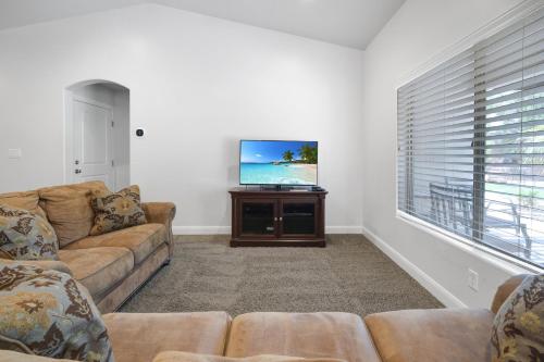 a living room with a couch and a flat screen tv at Cozy Home Near Zion With Fire Pit & Patio Dining in La Verkin