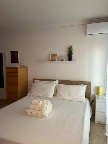 Una cama blanca con toallas encima. en Cozy apartment 5 min to the sea and airport, en Isola Sacra