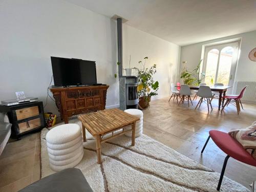 a living room with a television and a table and chairs at Kaza Blue - Maison familiale Rambouillet centre in Rambouillet