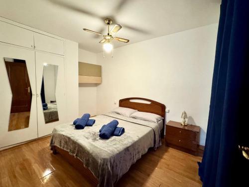 Un dormitorio con una cama con dos toallas azules encima. en Apartsalou Oasis, en Salou