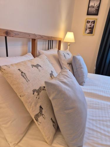 a bedroom with a bed with pillows on it at Maczka Apartament in Łódź