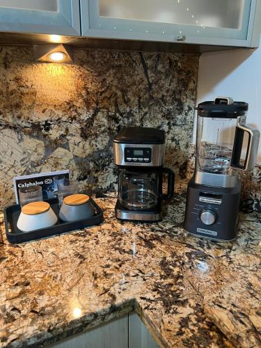 a kitchen counter with a coffee maker and a blender at Casa Bote Con Vista a Los Canales De Lecheria Con Muelle Privado in Las Garzas