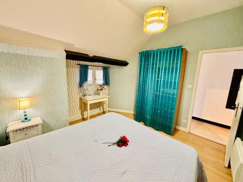 a bedroom with a white bed with a flower on it at Gîtes Montvaltin - Duplex 65 m2, 2 chambres in Le Breuil