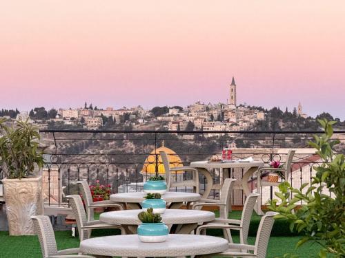 a group of tables and chairs on a balcony with a view at New Imperial Hotel in Jerusalem