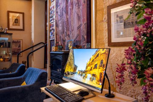 a computer monitor sitting on top of a desk at New Imperial Hotel in Jerusalem