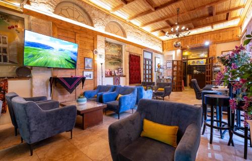 a waiting room with blue chairs and a large screen at New Imperial Hotel in Jerusalem