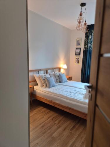 a bedroom with a large bed with blue pillows at Maczka Apartament in Łódź