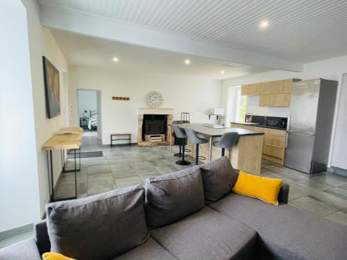 a living room with a couch and a kitchen at Maison proche de la Mer ! in Grues