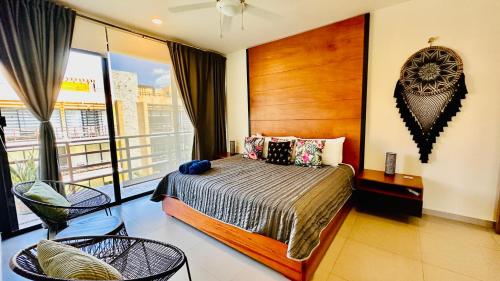 ein Schlafzimmer mit einem Bett und einem Balkon in der Unterkunft Lunada PH with Private Rooftop and Jacuzzi by Caribe Rentas in Playa del Carmen