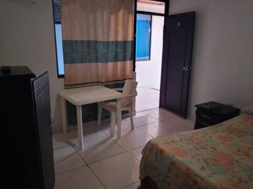 a bedroom with a desk and a table and a bed at Hotel Volga in Puerto López