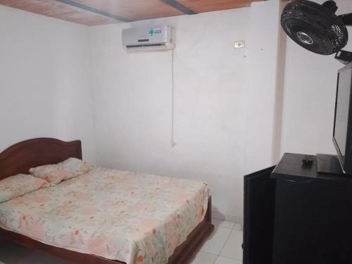 a bedroom with a bed and a television in it at Hotel Volga in Puerto López