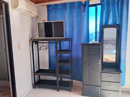 a television on a stand in a room with a dresser at Hotel Volga in Puerto López