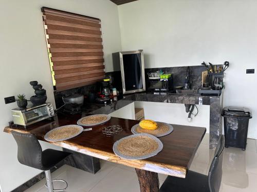 a kitchen with a wooden table with baskets on it at Tree of Heaven Lodge in San Isidro