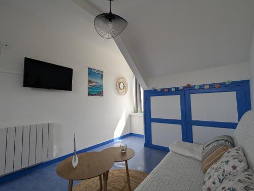 カンカルにあるAppartement cosy - aperçu mer - proche du sentierのリビングルーム(ソファ、青いドア付)
